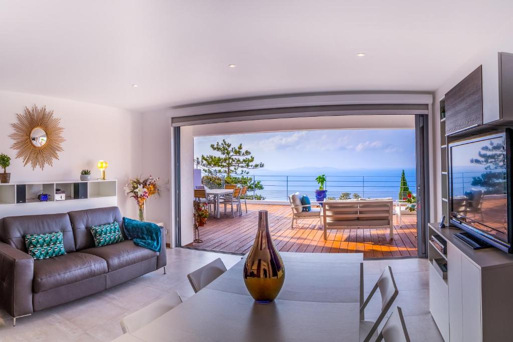 a living room with a view of the ocean at Vistazur Luxueux appartement avec terrasse et piscine in Rayol-Canadel-sur-Mer