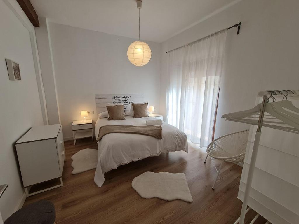 Alojamientos Segóbriga Rural (Montaña) في سيجوربي: غرفة نوم بيضاء بها سرير ونافذة