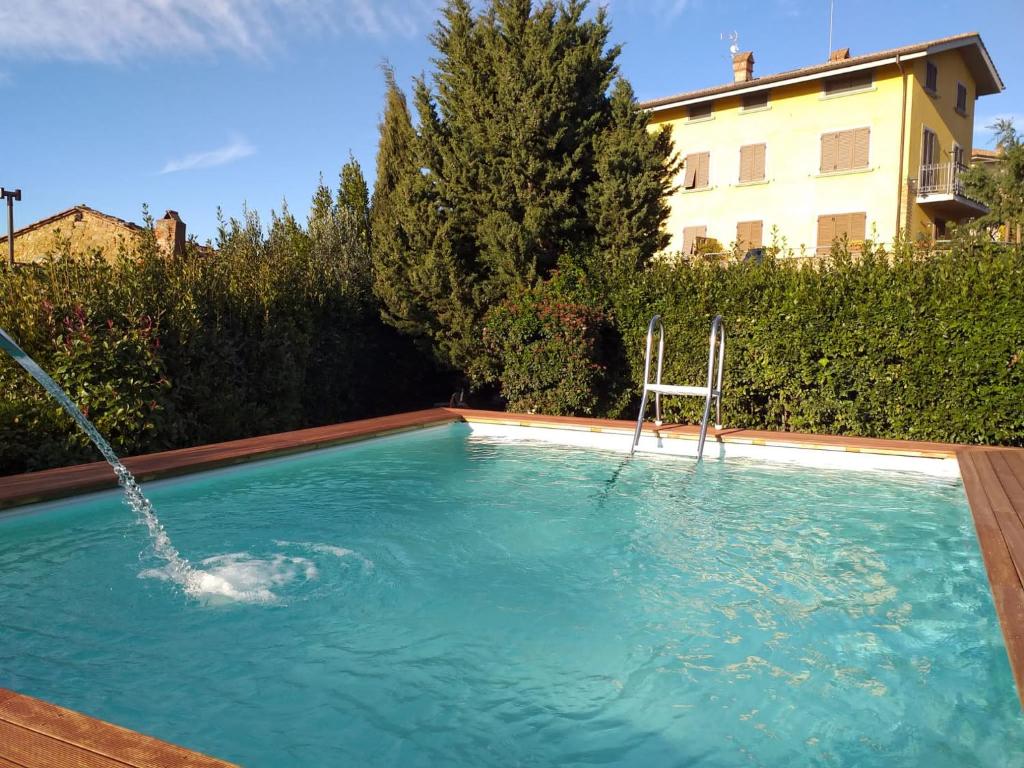 una piscina con una sedia e una fontana di Villa Antico Borghetto Di Tigliano a Vinci