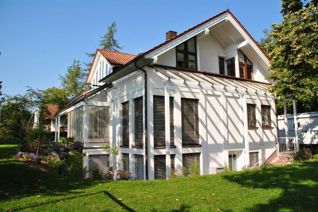 a white house with shutters on a yard at Ferienwohnung Finja in Bad Dürrheim