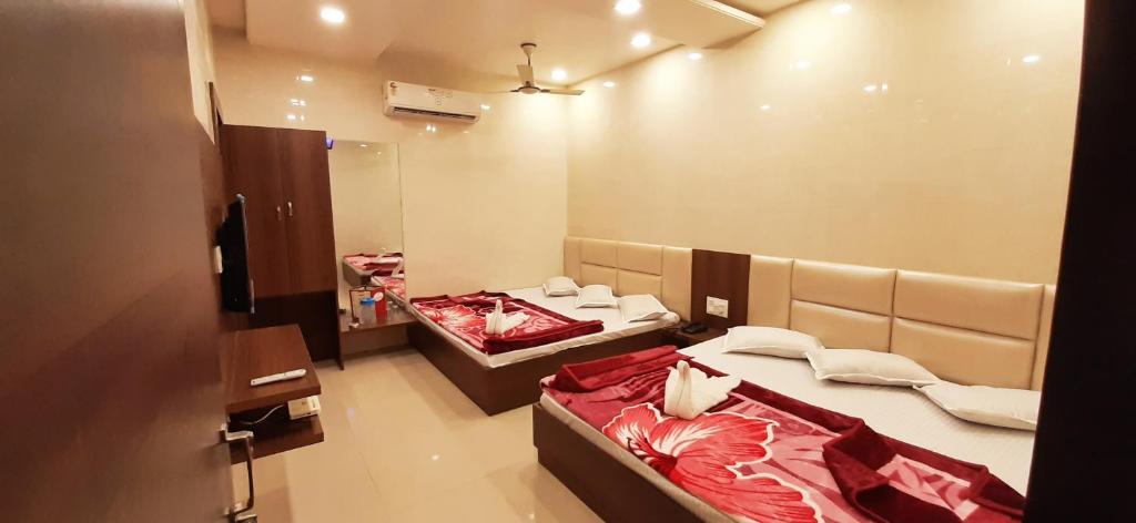 a room with two beds and a mirror at Ashiyana Inn Hotel in Ajmer