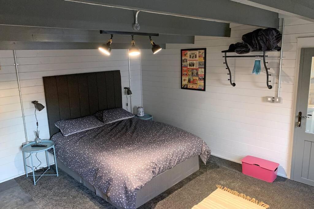 ein Schlafzimmer mit einem Bett in einem Zimmer in der Unterkunft Cosy, Self-Contained Garden Room in City Centre! in Hereford