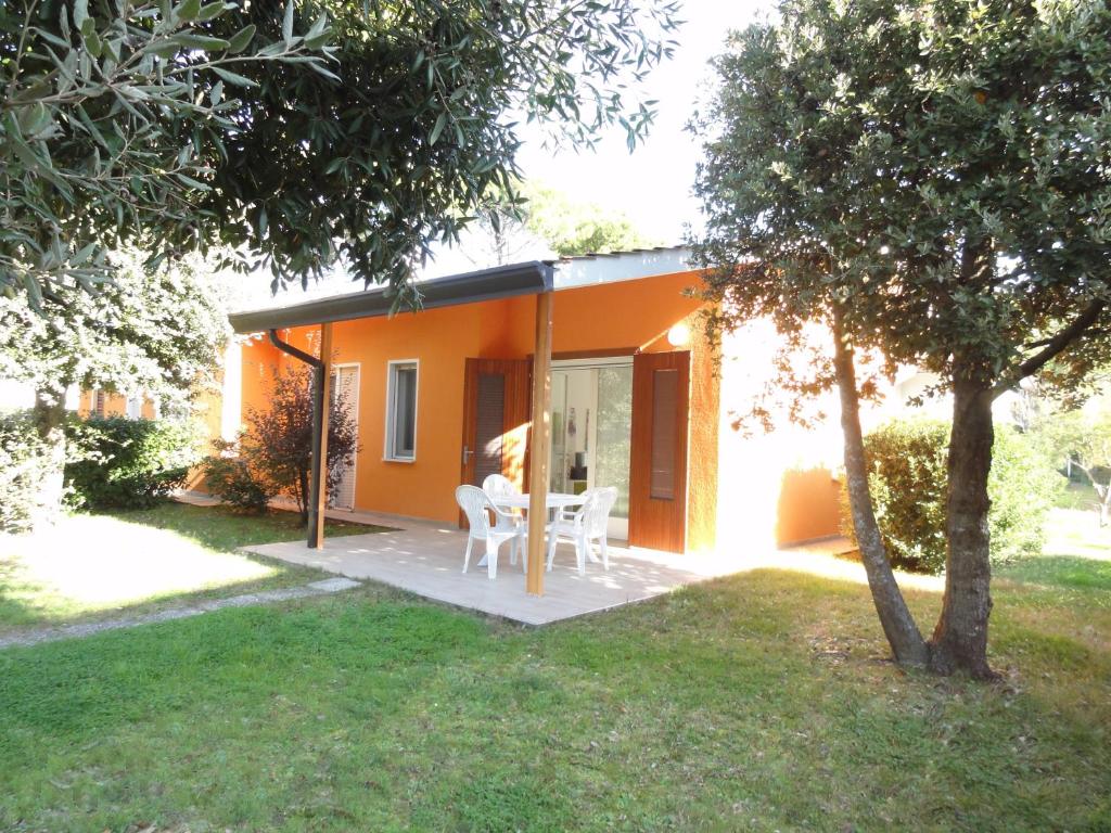 una casa con tavolo e sedie in cortile di Villa Dogi Sud 20 a Bibione