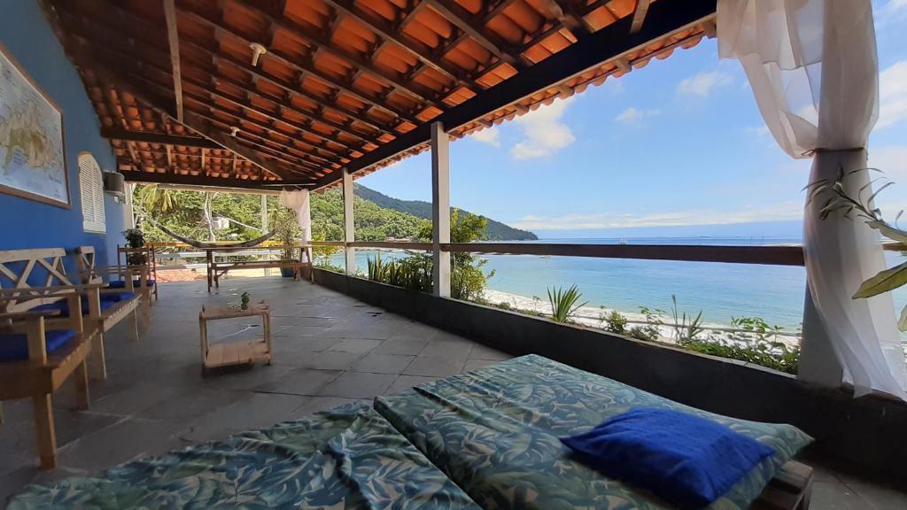1 dormitorio con cama y vistas al océano en Pousada da Ponte en Praia de Araçatiba