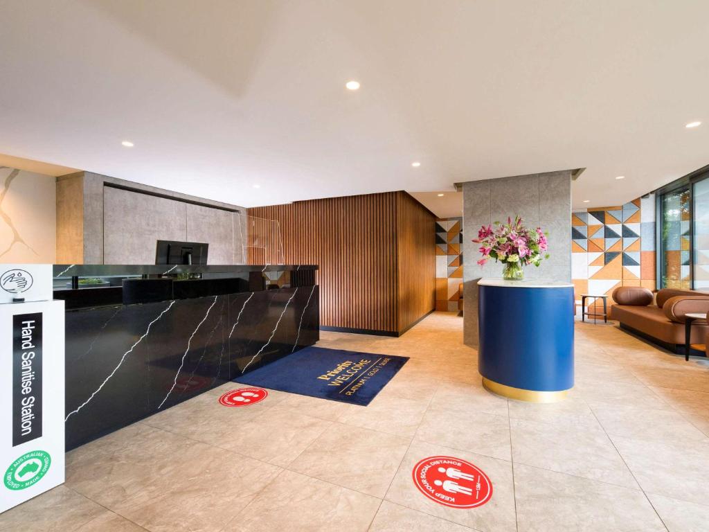 a lobby with a reception desk in a building at The Sebel Melbourne Moonee Ponds in Melbourne