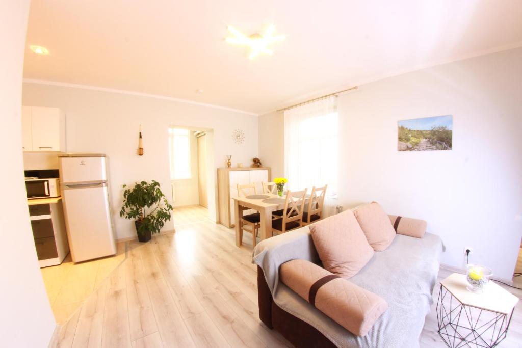 a living room with a couch and a kitchen with a table at Apartamenty u Piątków in Karpacz
