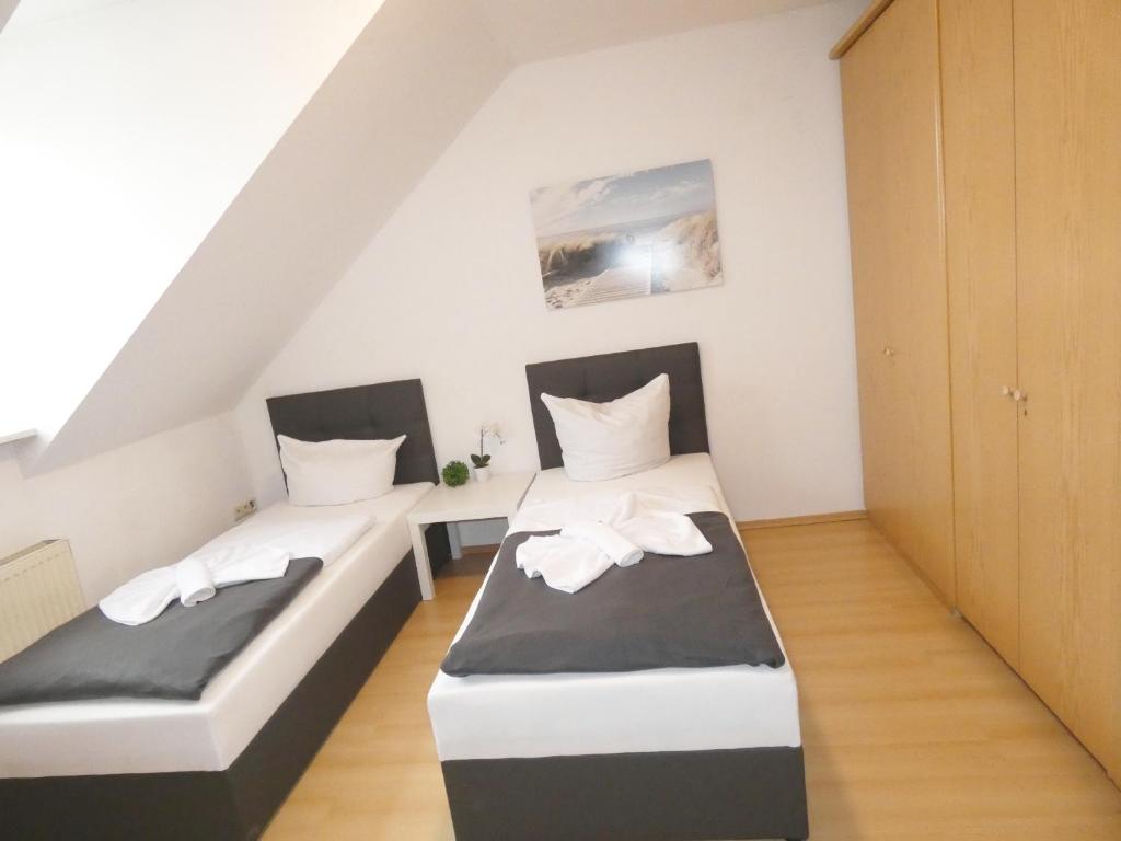 - deux lits dans une chambre blanche et noire dans l'établissement SUNNYHOME Monteurwohnungen und Apartments in Wackersdorf, à Wackersdorf