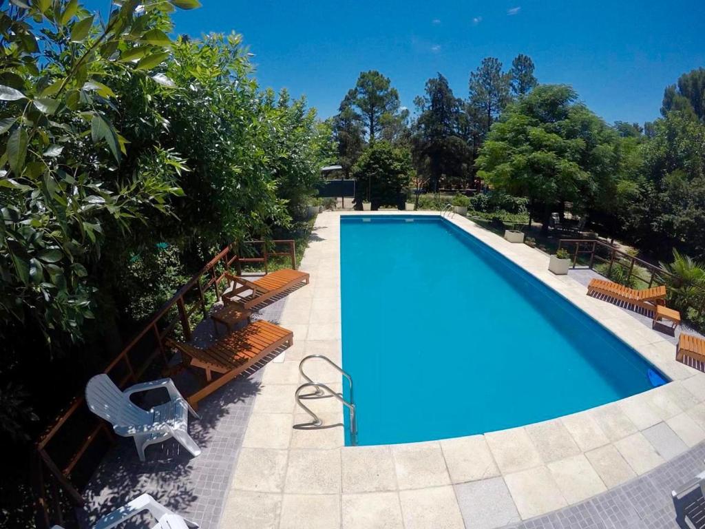 uma piscina com bancos e uma piscina azul em Hotel Complejo Najul Suites-Solo Adultos em Mina Clavero