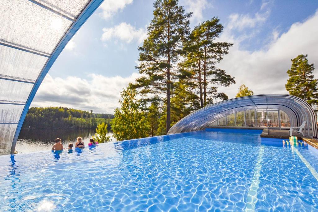a group of people swimming in a swimming pool at Årjäng Camping & Stugor Sommarvik in Årjäng