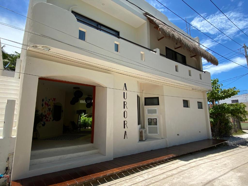 a white building with a sign that reads akronron real at AURORA in Holbox Island