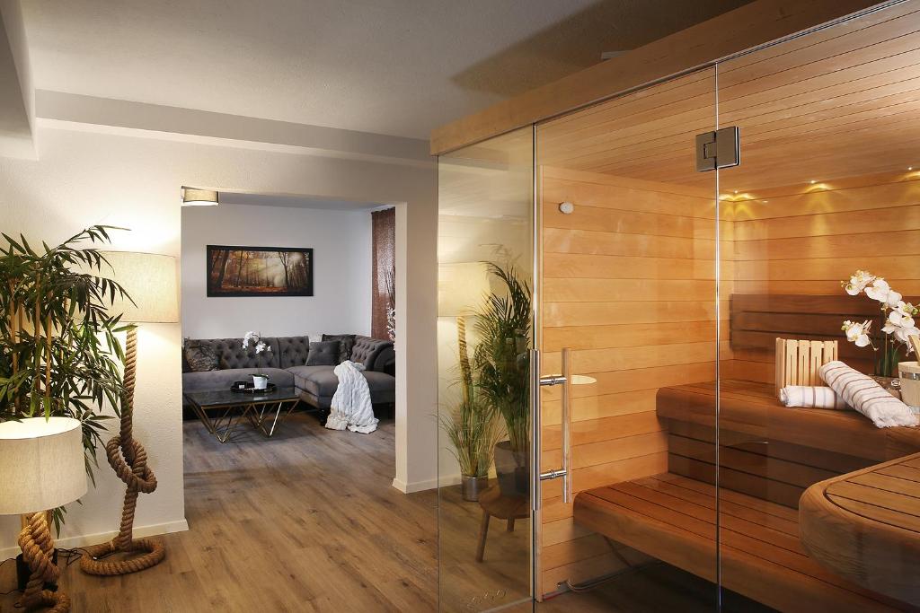 a living room with a glass shower and a couch at Private Spa LUX with Whirlpool and Sauna in Zurich in Zurich