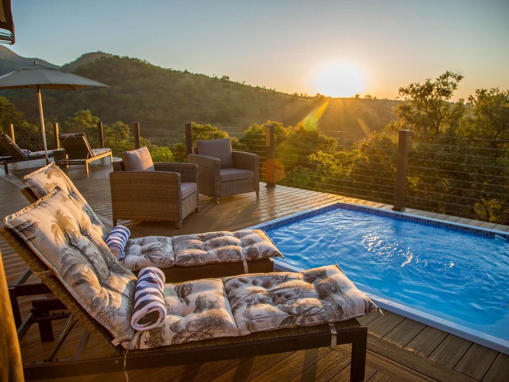 a couch sitting on a deck next to a swimming pool at Nkomazi Game Reserve by NEWMARK in Badplaas