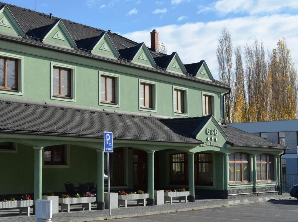 a large green building with a black roof at G&G penzion in Šaľa