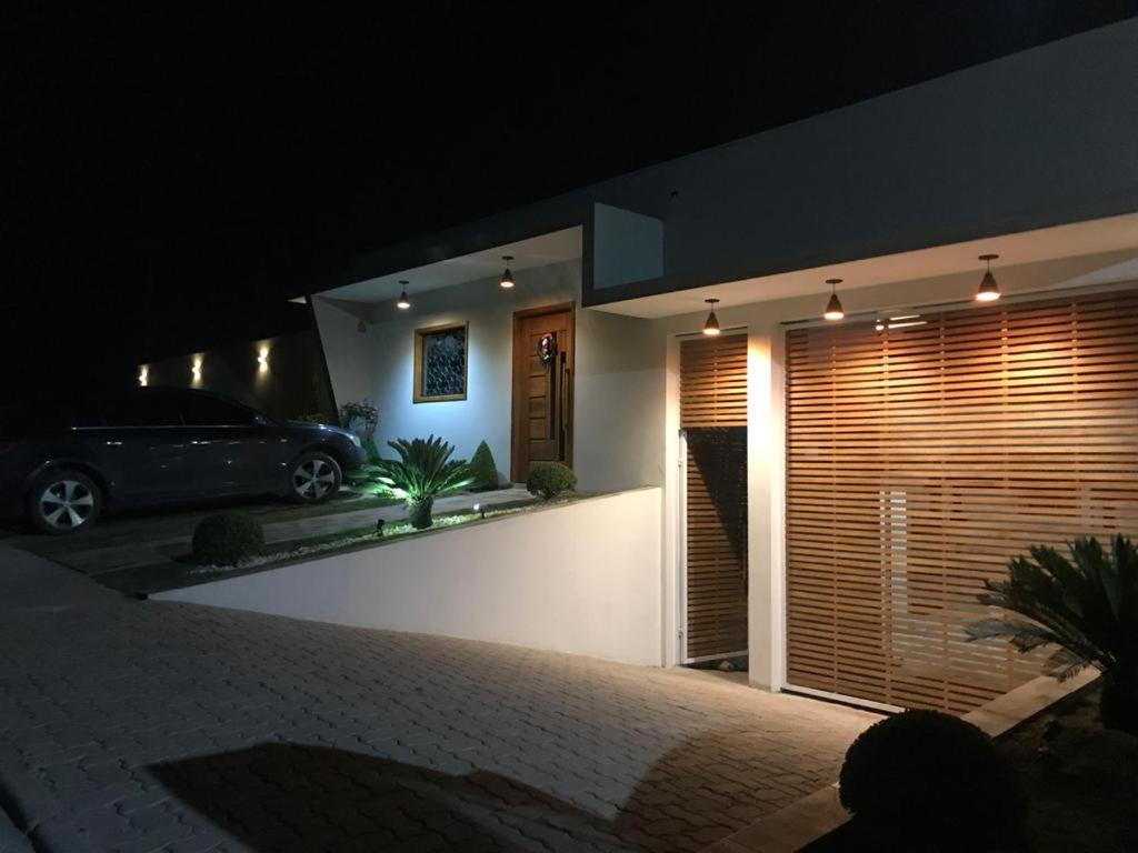 a car parked in front of a house at night at Pousada Pôr do Sol in Cunha