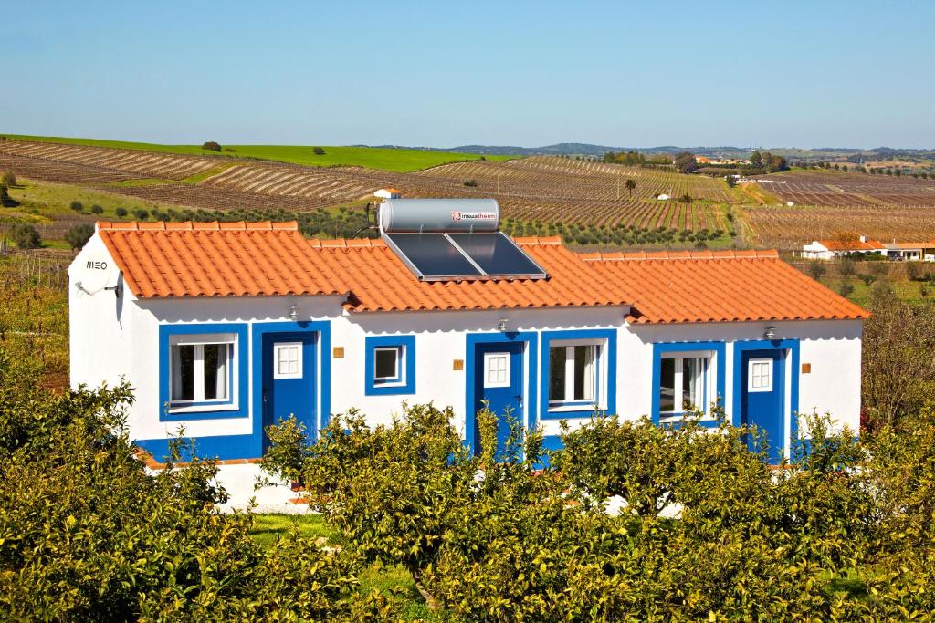 een huis met een oranje dak en een zonnepaneel erop bij Outeiro do Barro in Reguengos de Monsaraz