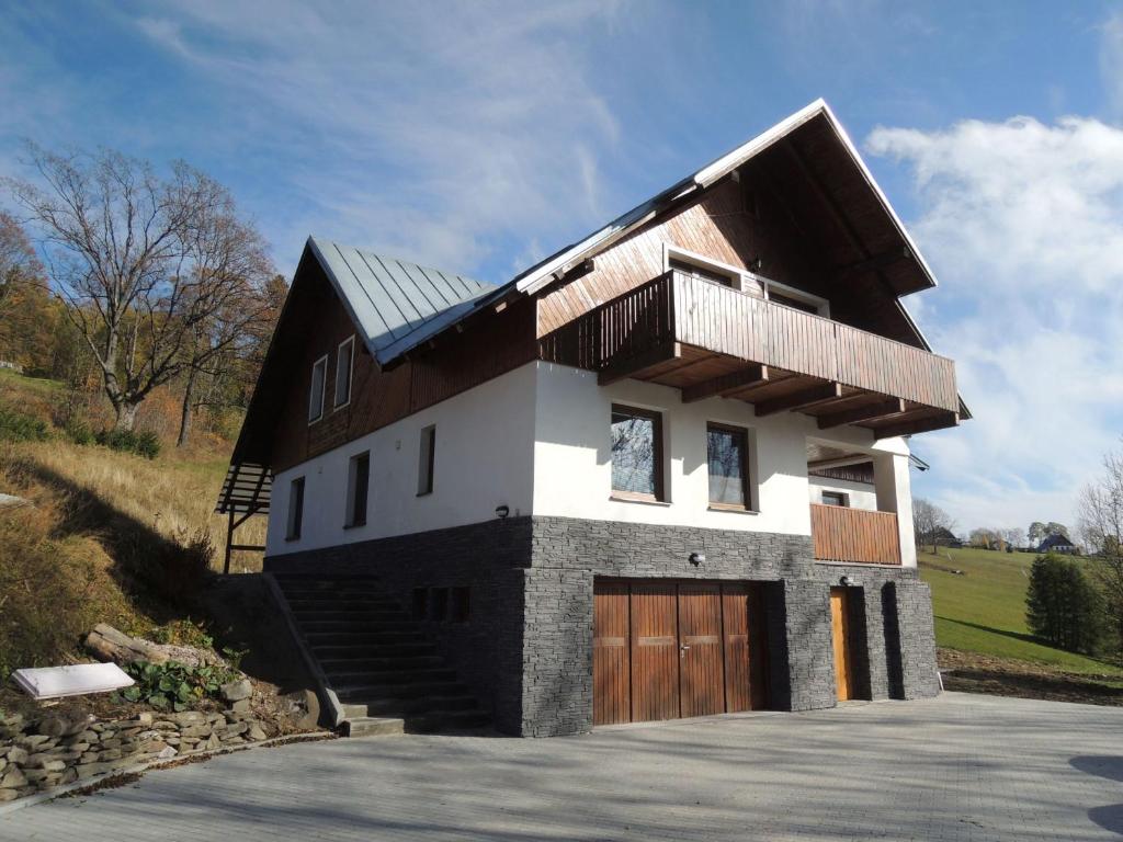 a house with a gambrel roof with a garage at Chata Nový svět in Strážné