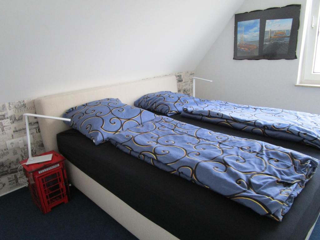 een bed met een blauw dekbed in een kamer bij Bed & Breakfast Wunstorf in Wunstorf