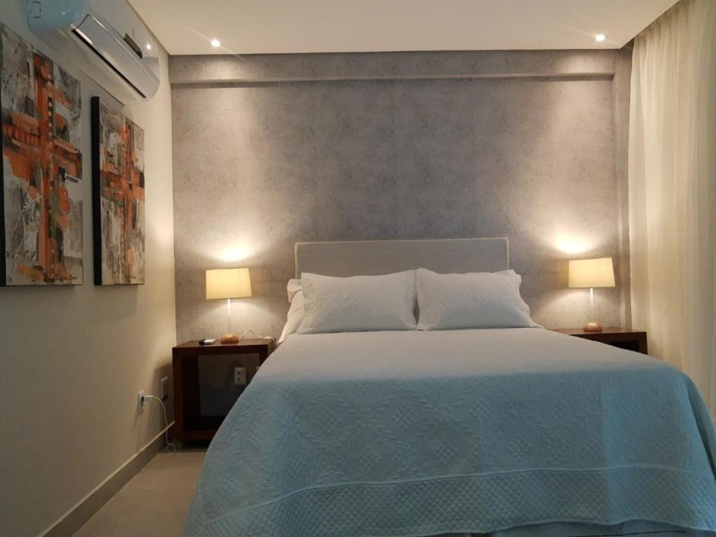 1 dormitorio con 1 cama grande y 2 lámparas en las mesas en FLAT NA PRINCIPAL DE PIPA en Pipa