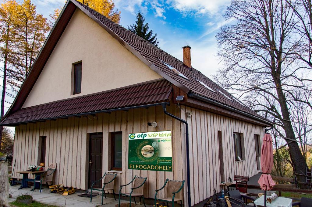 a building with chairs and a sign on it at Mantara Vendégház in Matraszentlaszlo