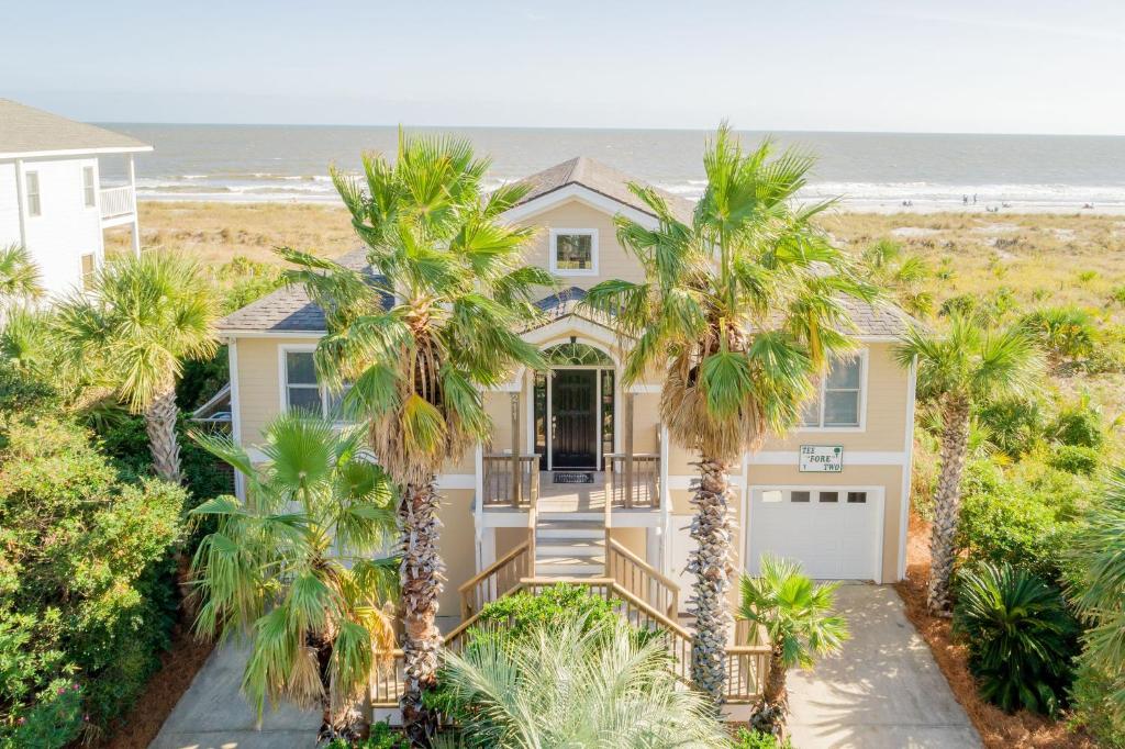 uma casa com palmeiras em frente à praia em 211 E Arctic - Tee Fore Two - Oceanfront - 4 Bedrooms em Folly Beach