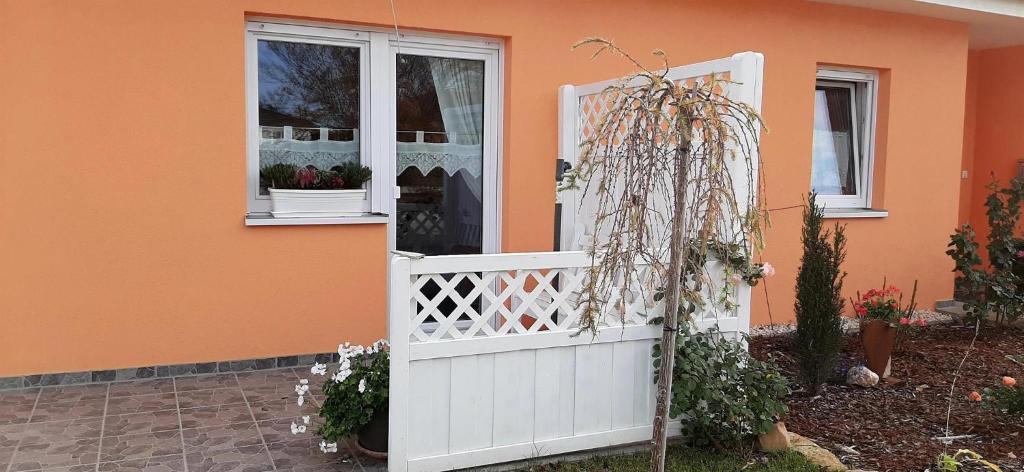 an orange house with a white gate and a window at Ferienwohnung Weinbergblick in Naumburg