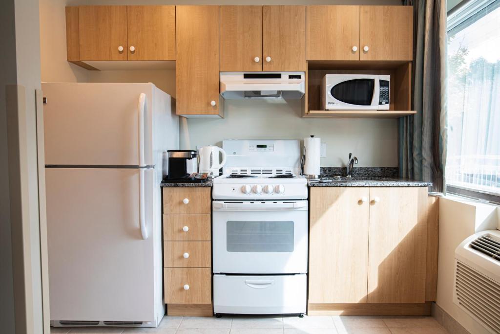 a kitchen with white appliances and wooden cabinets at The Business Inn in Ottawa