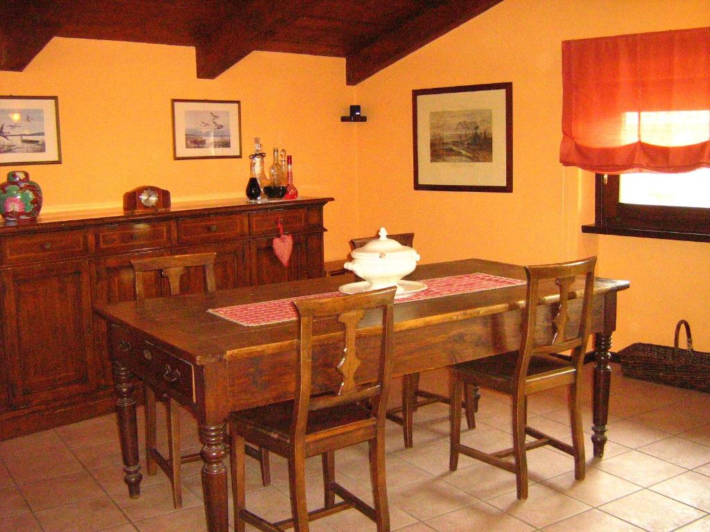 comedor con mesa de madera y sillas en B&B Casa Dolce Casa, en Candelo