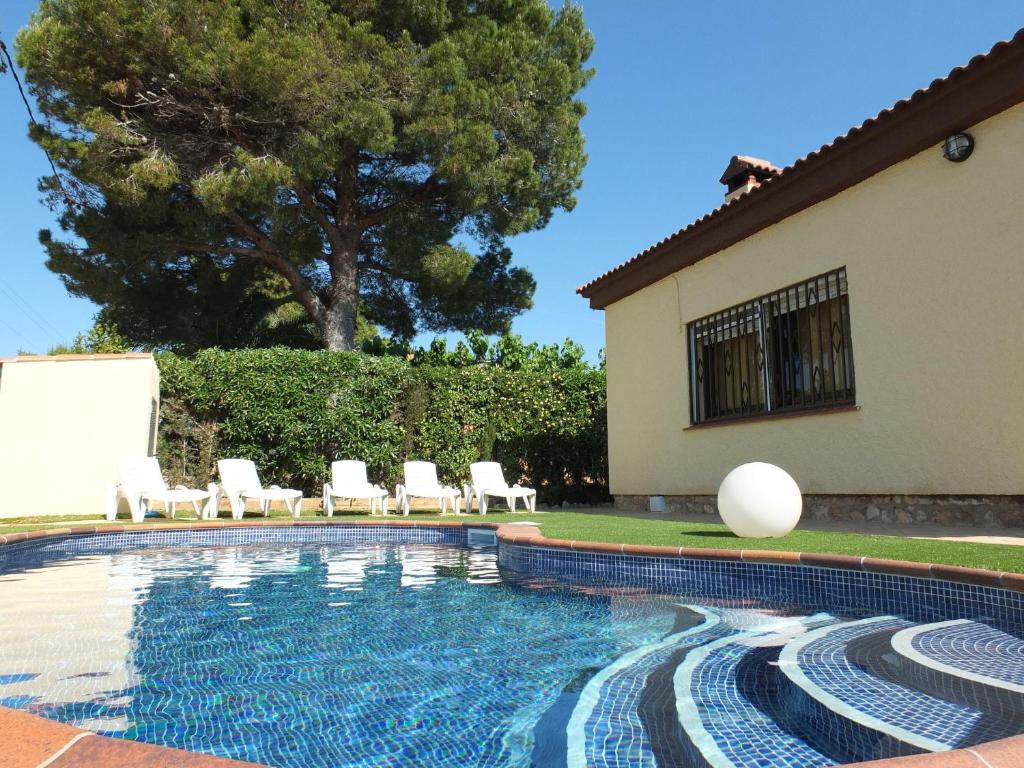 ラメトリャ・デ・マールにあるVilla Esperanza 4bedroom villa with air-conditioning & private swimming poolのスイミングプール(椅子付)と家