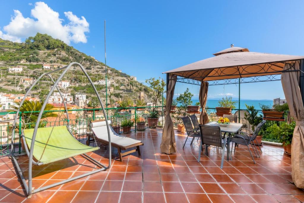 a patio with a table and chairs and a gazebo at Casa Amena in Minori