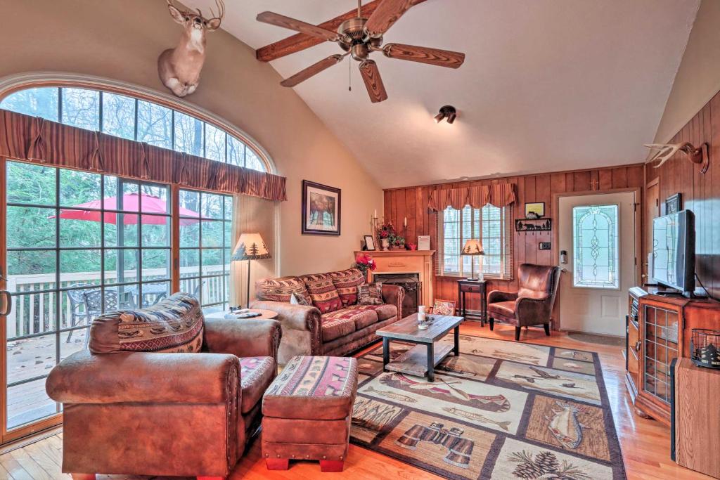 a living room with leather furniture and a ceiling fan at Poconos Home with Game Room Walk to Lake Harmony! in Lake Harmony