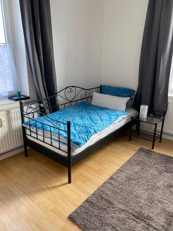 a bedroom with a bed with blue sheets and a rug at WG Zimmer 108 in Holzminden