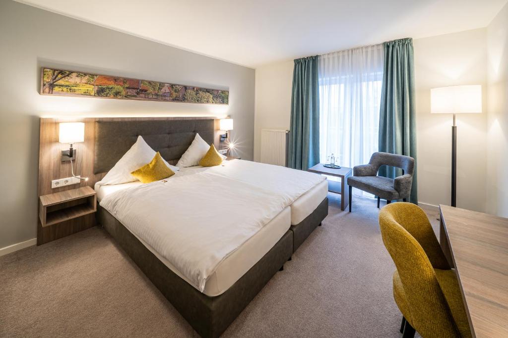 um quarto de hotel com uma cama grande e uma secretária em Hotel Meyerink em Vreden