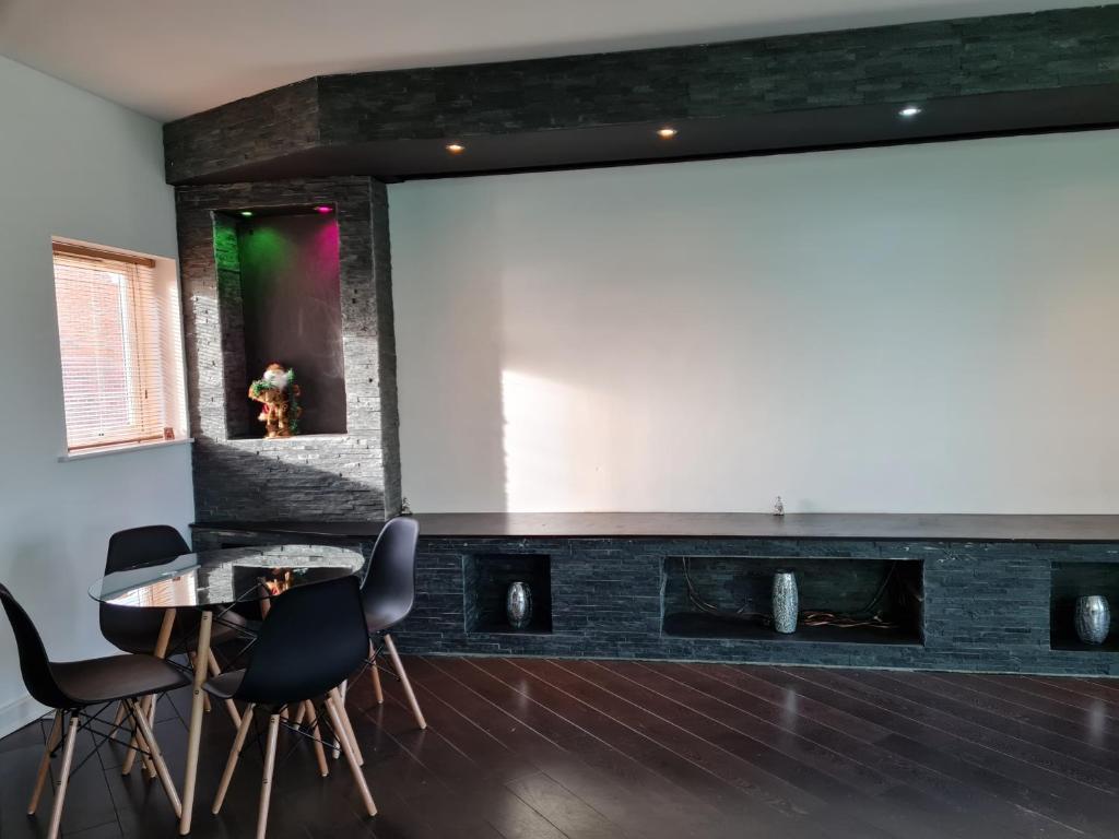 a living room with a large projection screen and a table and chairs at Stockton Heights, Warrington, Centrally Located Between Town Centre and Stockton Heath, High Speed Wifi, Cozy Stay in Warrington