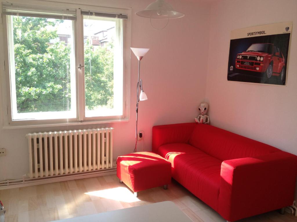 a living room with a red couch and a window at "IDEAL" - für Zwei in Berlin