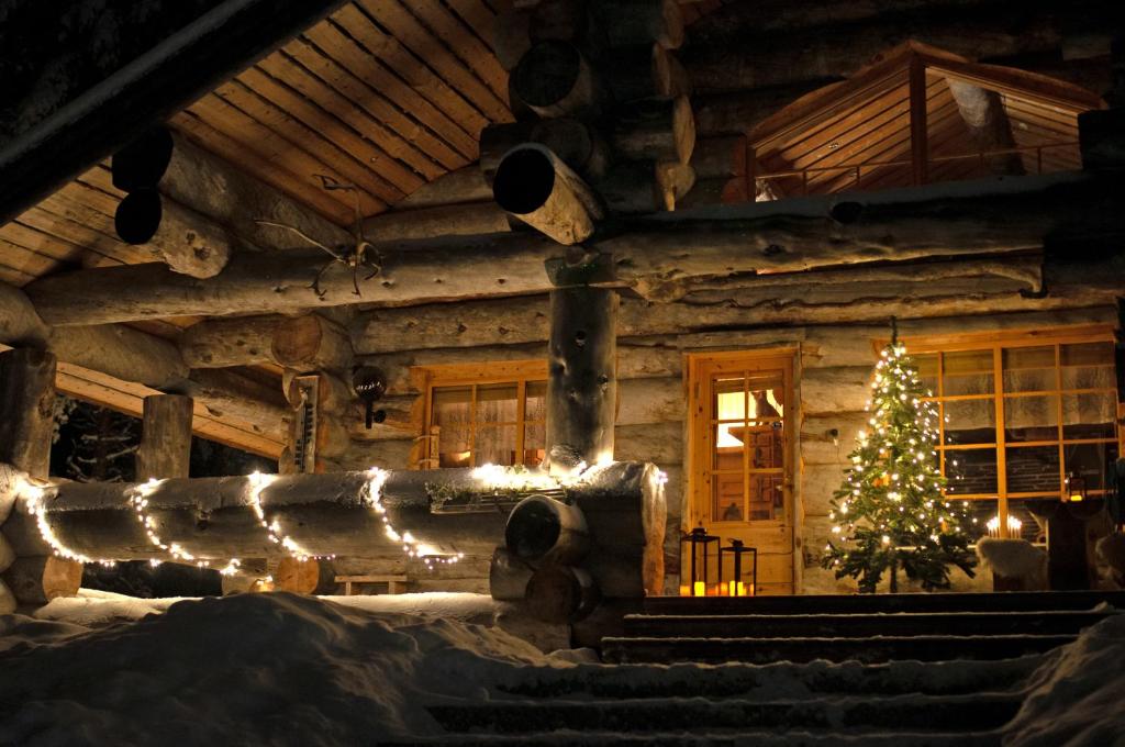 a christmas tree in a log cabin with lights at Villa Rukapiste in Ruka