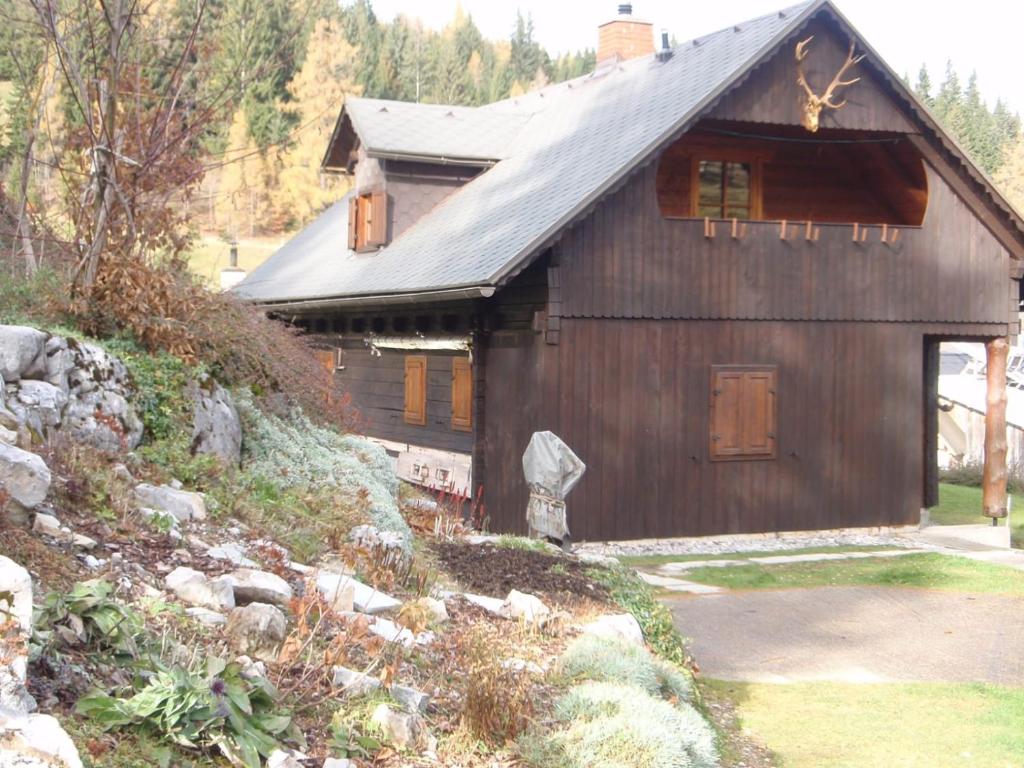 uma pequena casa de madeira com um telhado de gambrel em Almhütte Seeberg em Turnau