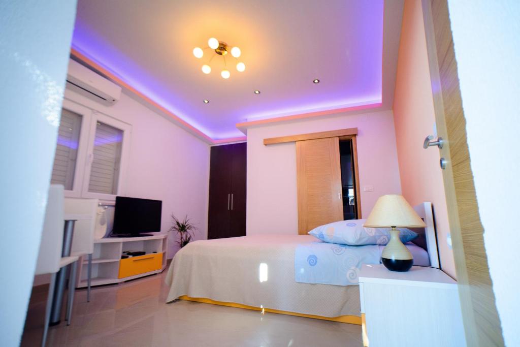 a bedroom with a bed with a purple ceiling at Lara Apartments in Makarska