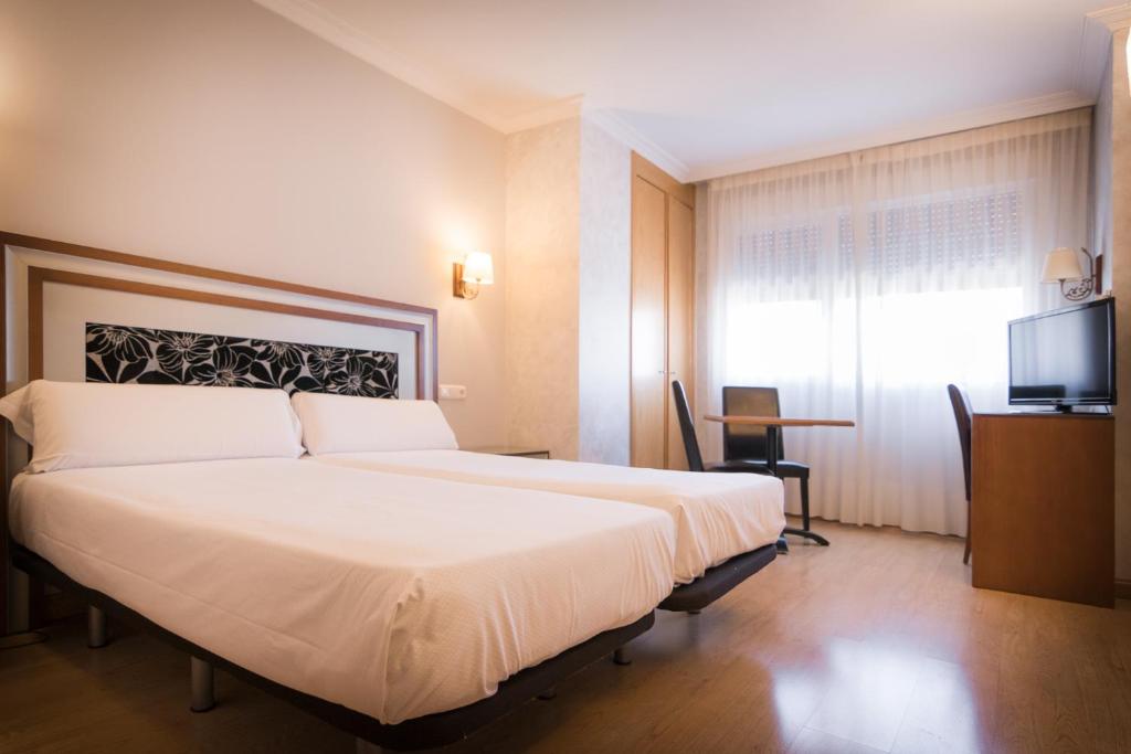 Cama o camas de una habitación en Abadía Burgos Camino Santiago
