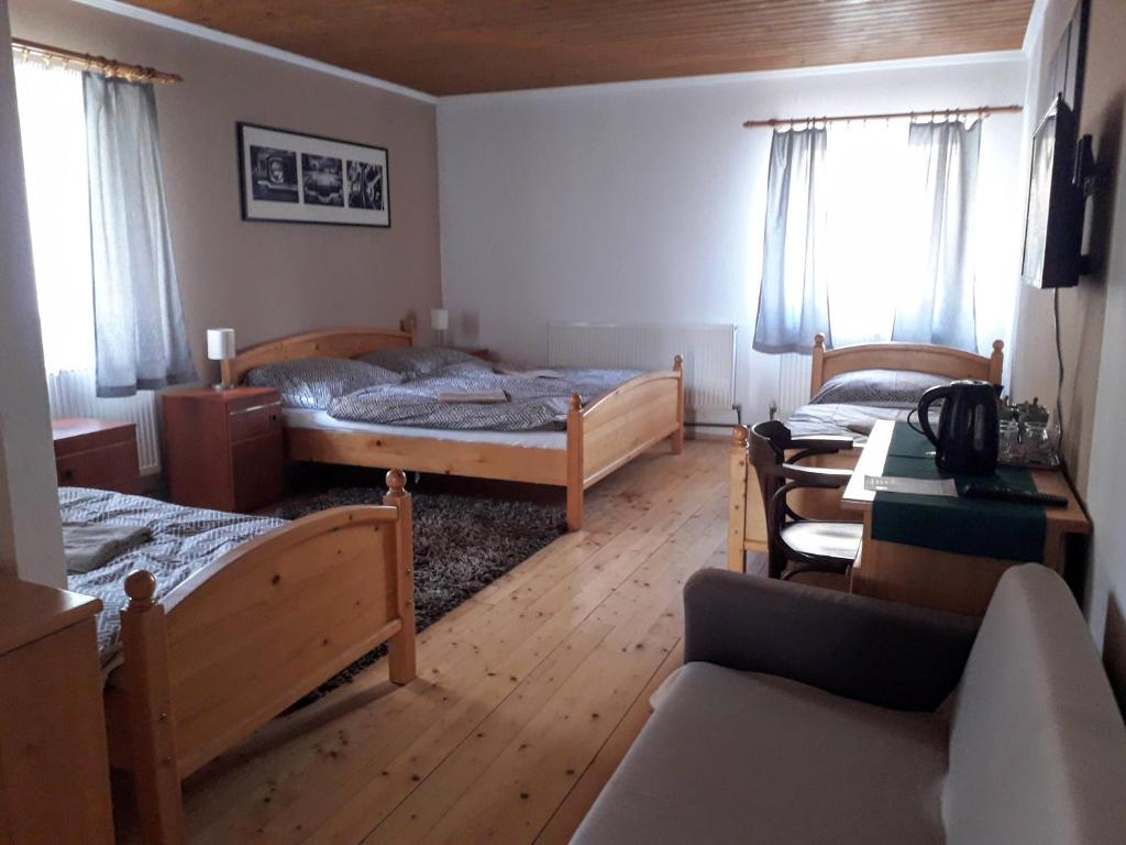 ポジェブラディにあるPenzion Na Střelniciのベッドルーム1室(ベッド2台付)、リビングルームが備わります。