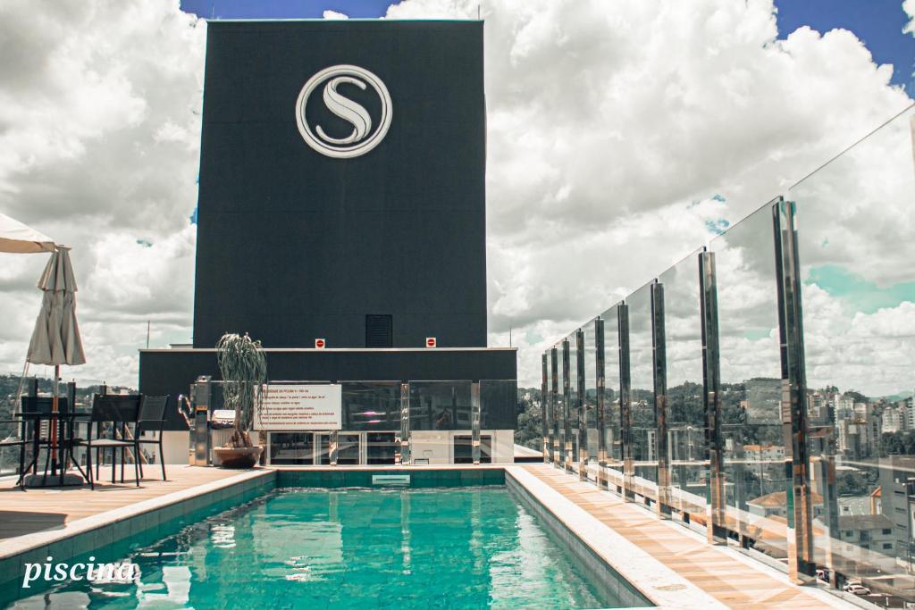 a swimming pool on top of a building with a clock tower at Loft próximo a Vila Germânica 310 in Blumenau