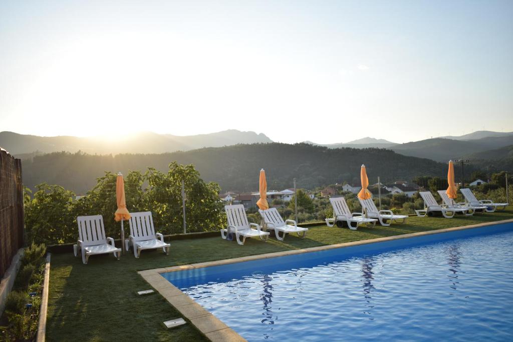 a group of lounge chairs next to a swimming pool at Casa da Eira in Janeiro de Cima