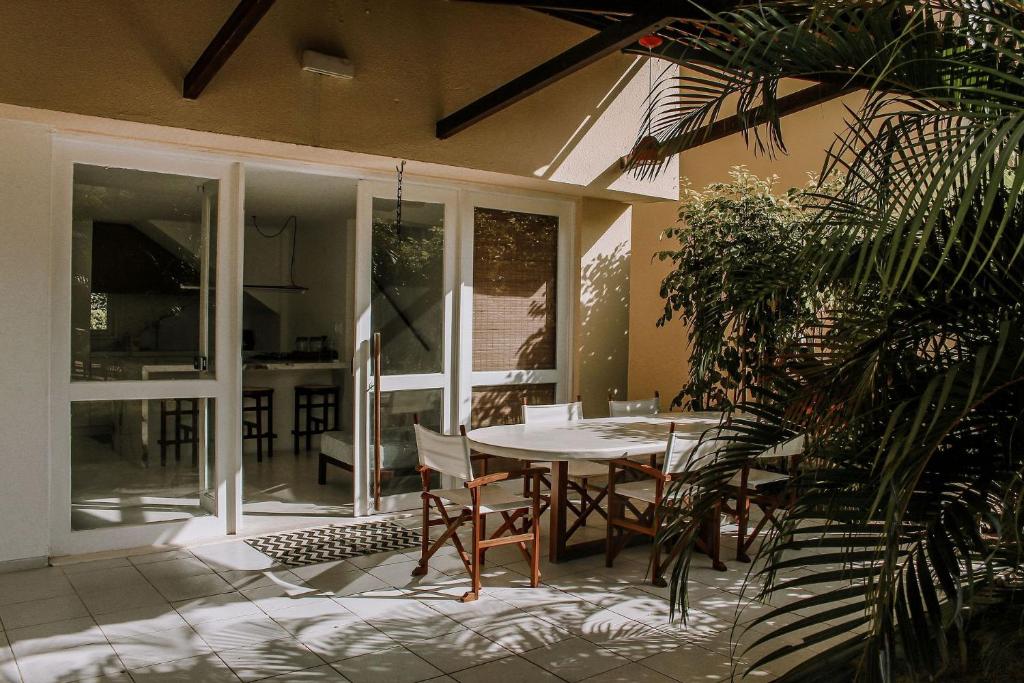 een patio met een tafel en stoelen op een huis bij Qavi - Pipa Atlântico Bungalow 08 in Pipa