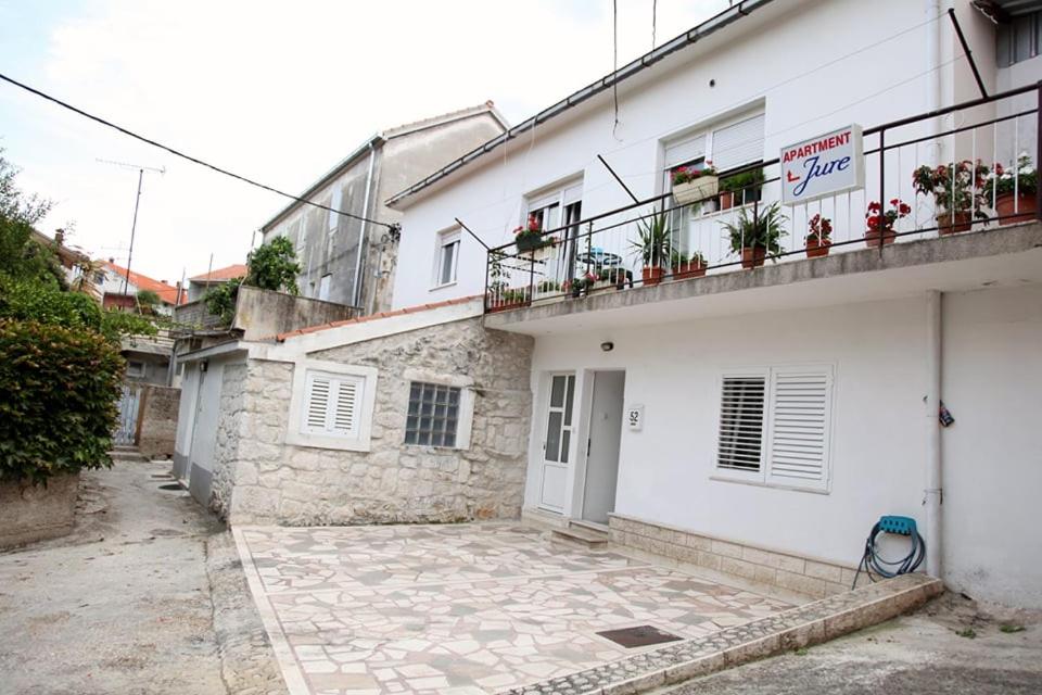 - un bâtiment blanc avec un balcon orné de plantes dans l'établissement Apartman Mantenjin, à Trogir
