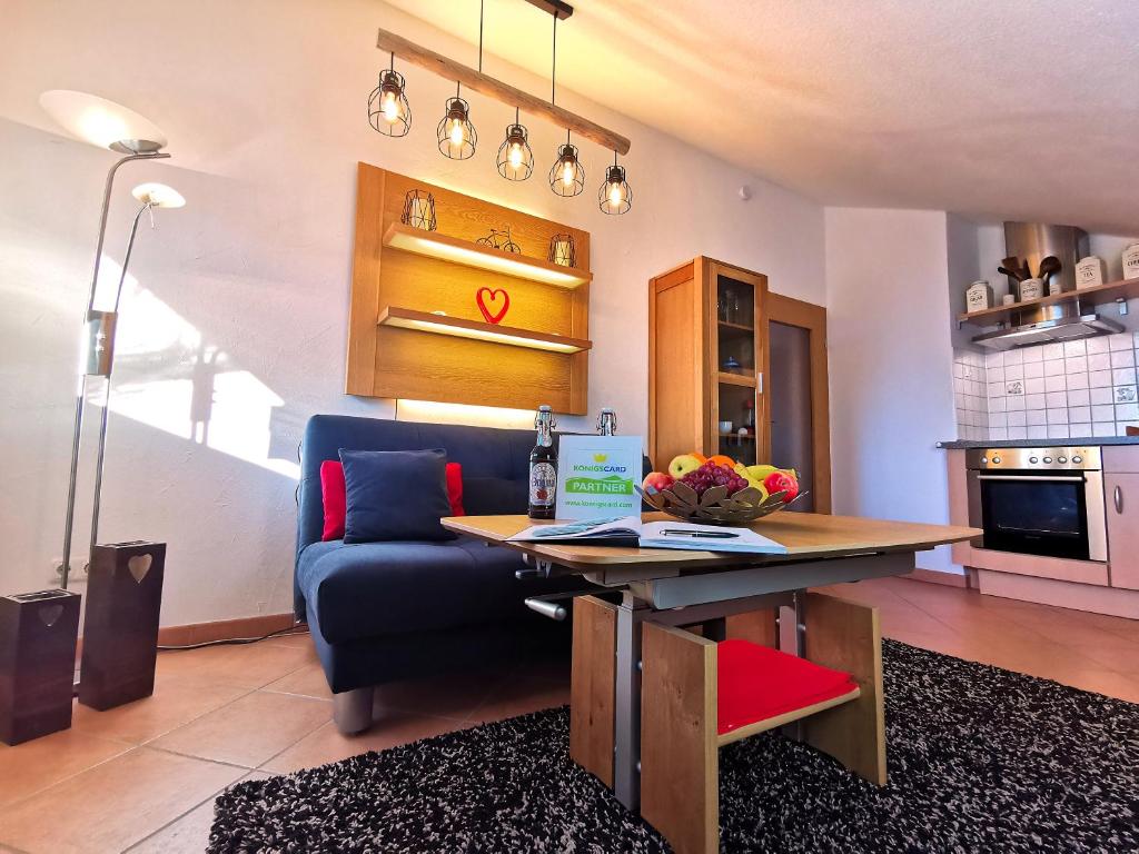 a living room with a table and a blue couch at Ferienhaus Alexandra in Nesselwang