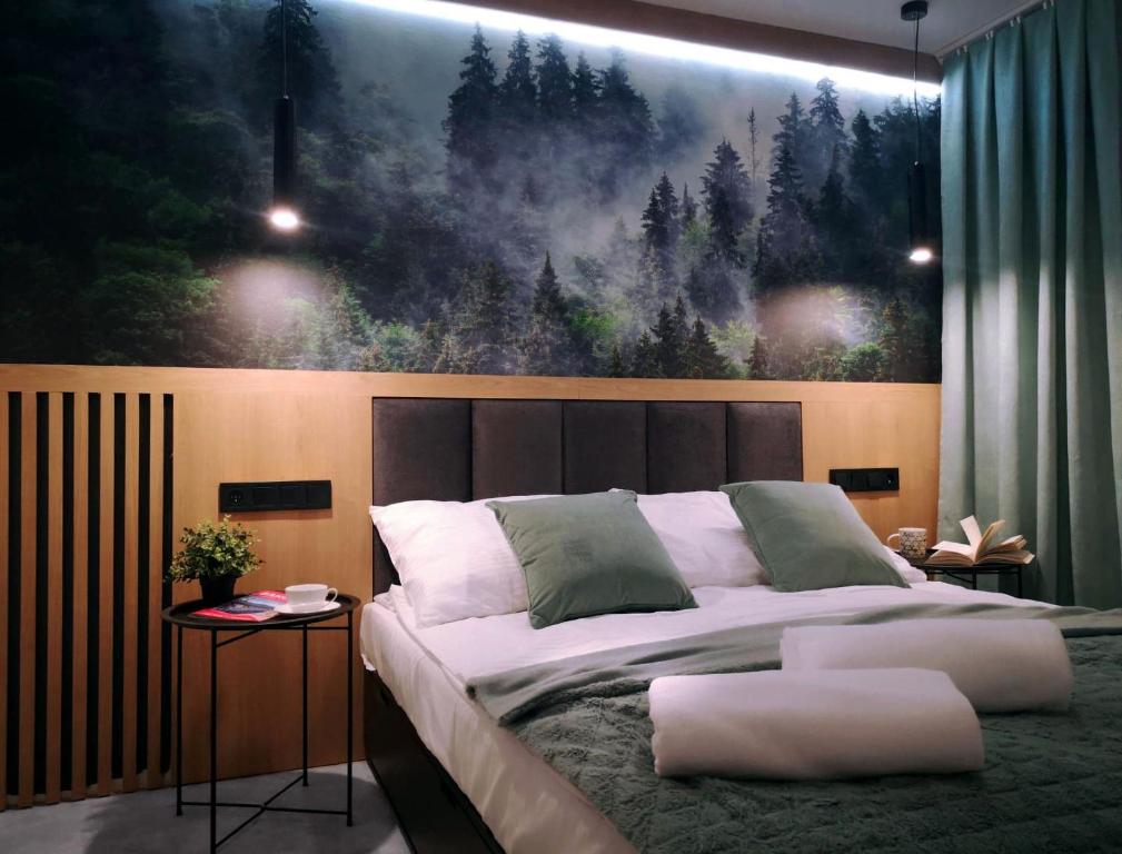 a bedroom with a bed with a large painting on the wall at Apartament Liliowa Przełęcz in Zakopane