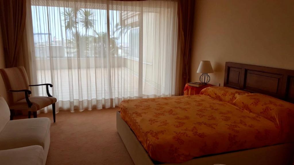 a bedroom with a bed and a large window at Palais Napoléon, Golfe Juan in Vallauris