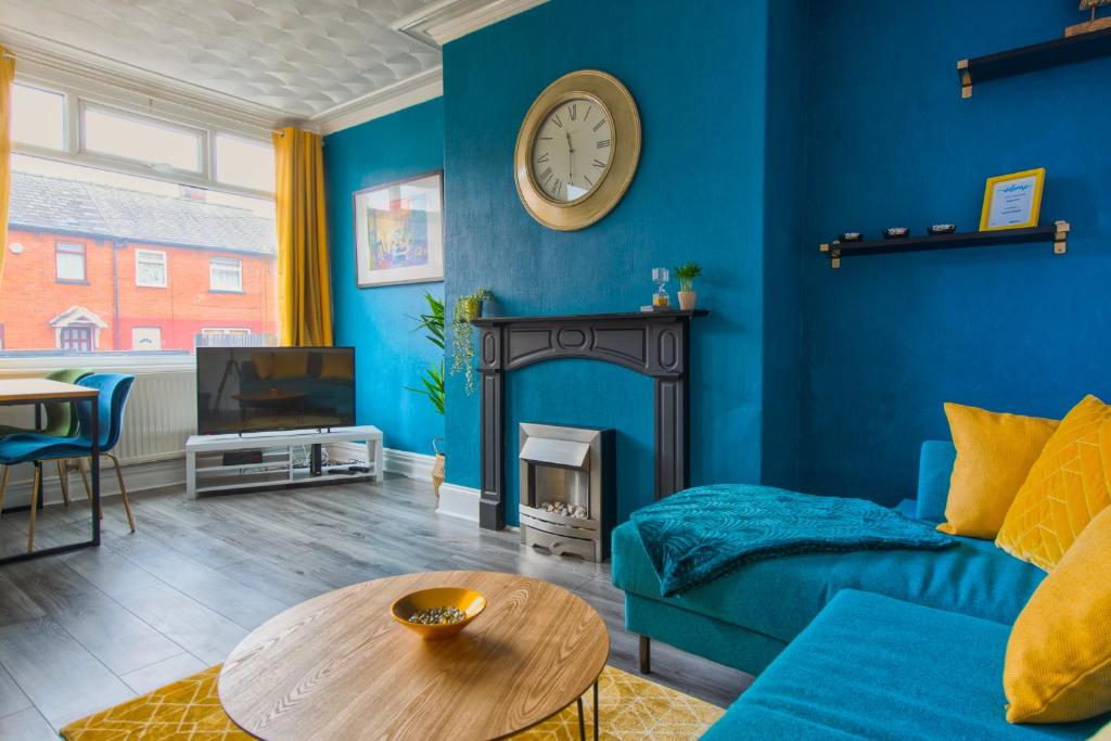 a blue living room with a couch and a table at Skelton house - shortstayleeds in Leeds