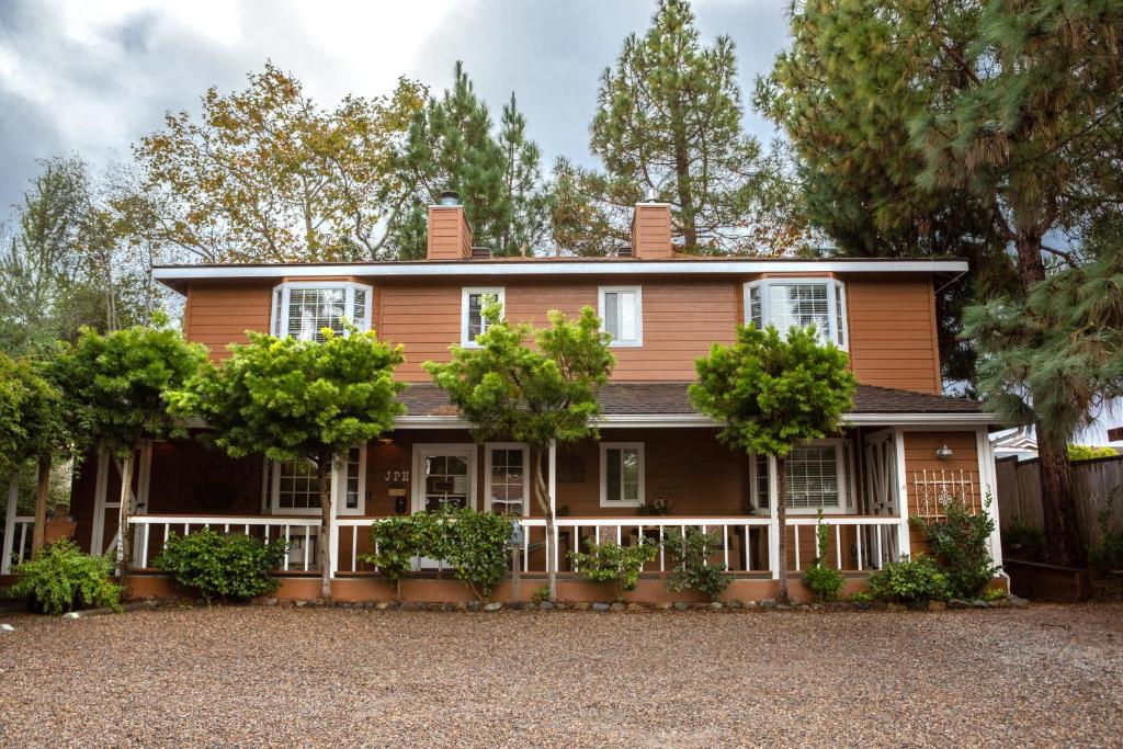 une vieille maison avec une clôture et des arbres dans l'établissement J Patrick Inn, à Cambria