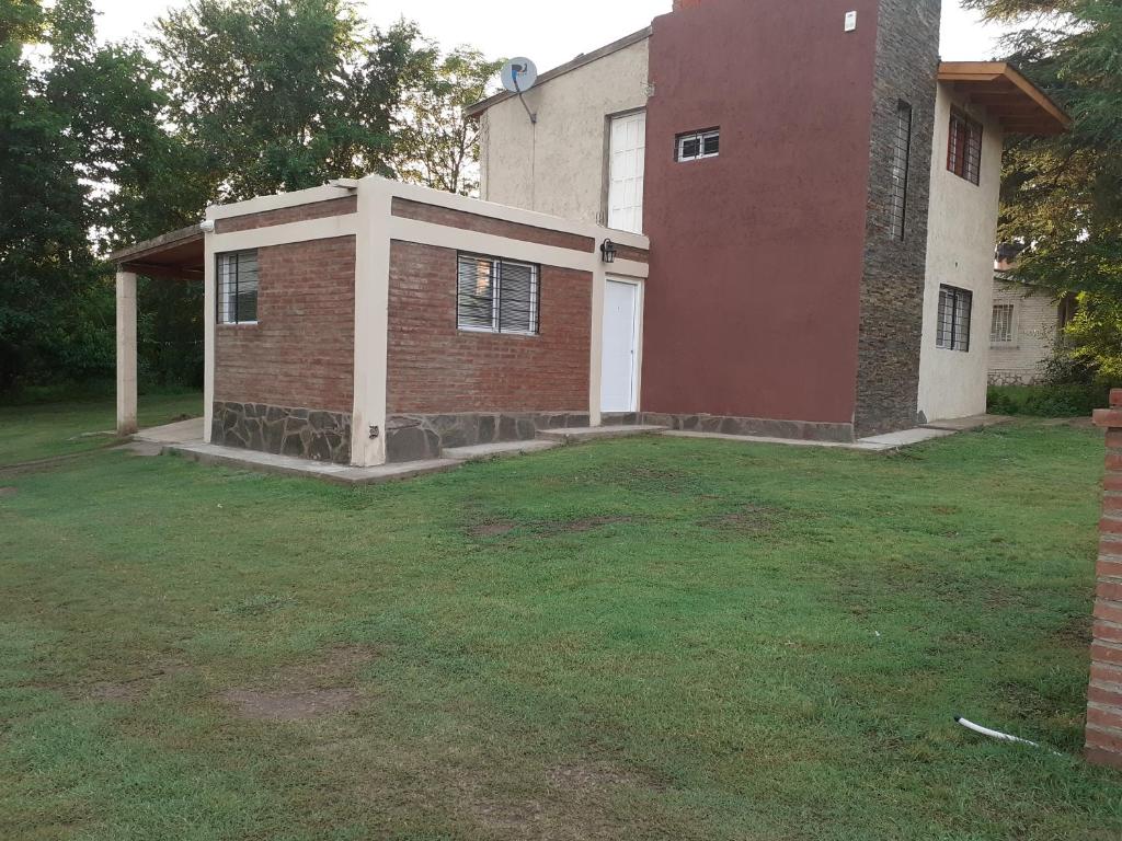 un gran patio con una casa de ladrillo y un edificio en Alquiler Santa Rosa en Santa Rosa de Calamuchita