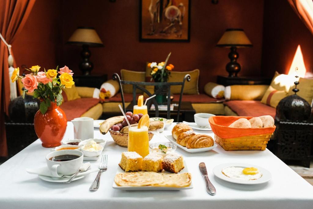 un tavolo con pane, prodotti da forno e tazze di caffè di Riad Pachavana a Marrakech